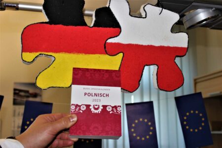 Foto des Sprachkalender Polnisch 2023 vor dem Hintergrund eines deutsch-polnischen Symbols